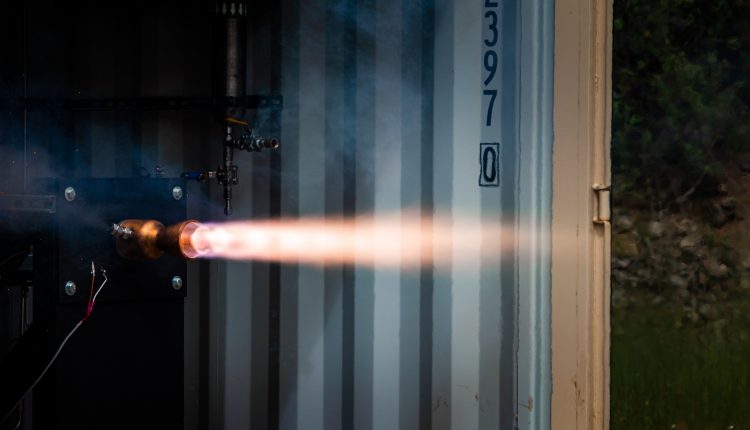 A missile makes a test fire in an industrial setting.